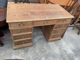 A VICTORIAN PITCH PINE KNEEHOLE DESK ENCLOSING NINE DRAWERS, WITH BRASS HANDLES, 51 X 26"