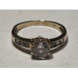 A 9 CARAT GOLD RING WITH A CENTRE CUBIC ZIRCONIA AND THREE TO EACH SHOULDER SIZE M