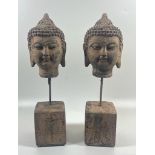 A PAIR OF DECORATIVE STONE BUDDHA HEADS ON PLINTH BASES, HEIGHT 30 CM