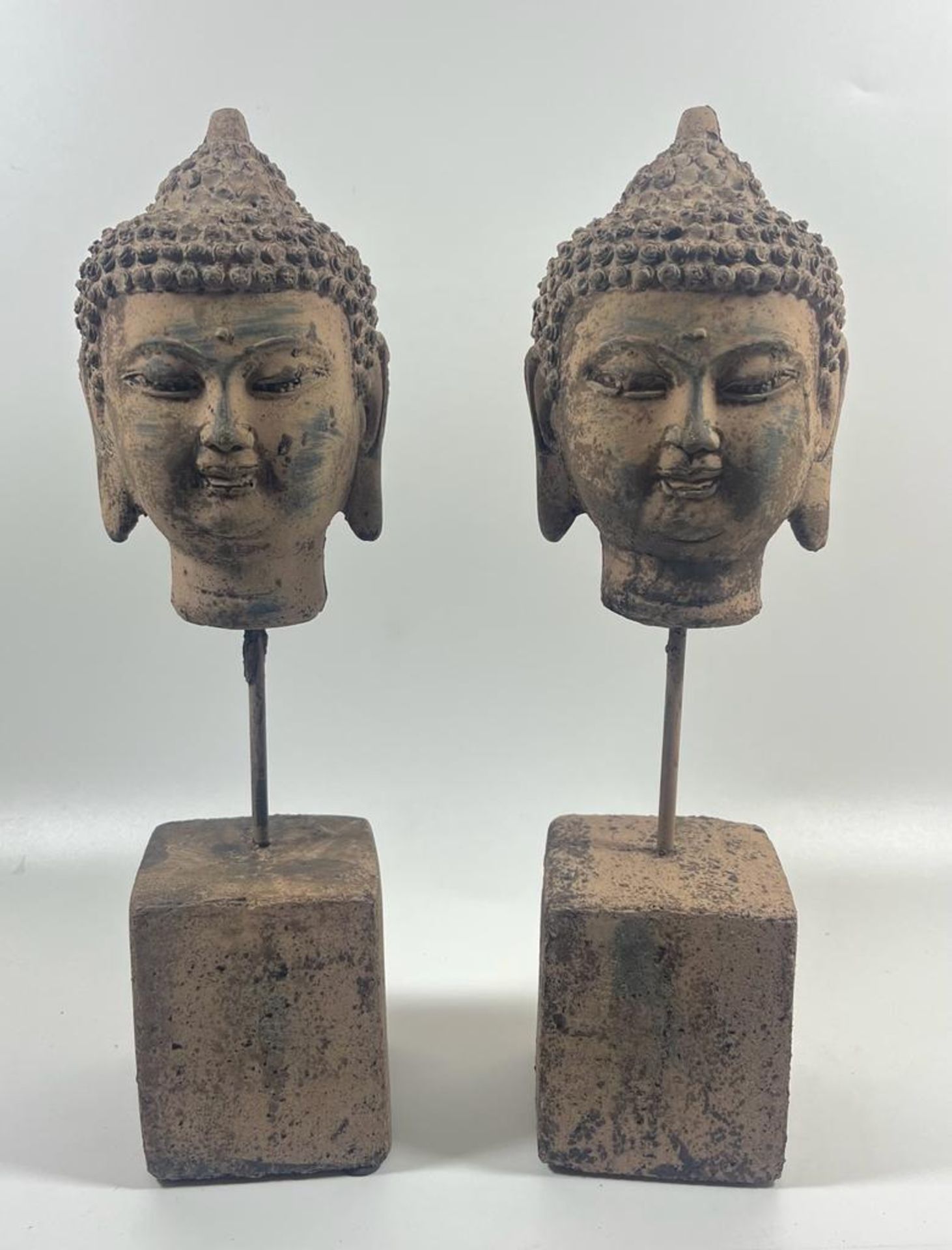 A PAIR OF DECORATIVE STONE BUDDHA HEADS ON PLINTH BASES, HEIGHT 30 CM