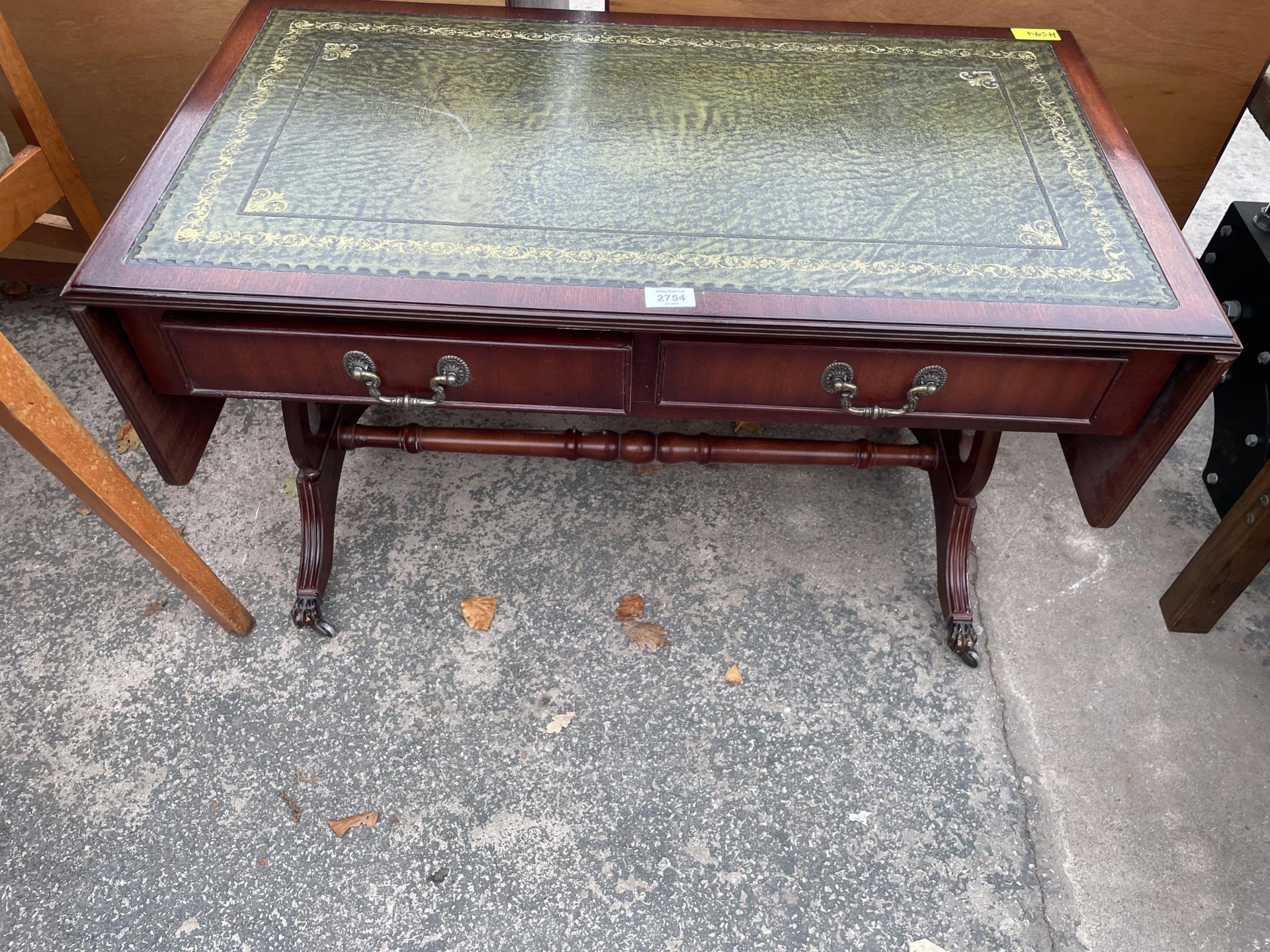 A LOW MAHOGANY SOFA TABLE WITH INSET LEATHER TOP WITH LYRE ENDS