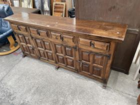 A MODERN SPANISH STYLE BEECH SIDEBOARD WITH RAISED PANELS AND IRONWORK HINGES AND HANDLE, 79" WIDE