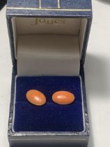 A PAIR OF 9 CARAT GOLD EARRINGS WITH CORAL COLOURED STONES