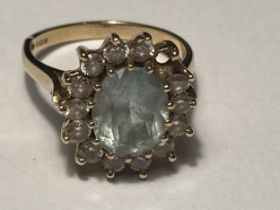 A 9 CARAT GOLD RING WITH A LARGE CENTRE STONE AND SURROUNDING CLEAR STONES SIZE N/O GROSS WEIGHT 4.7