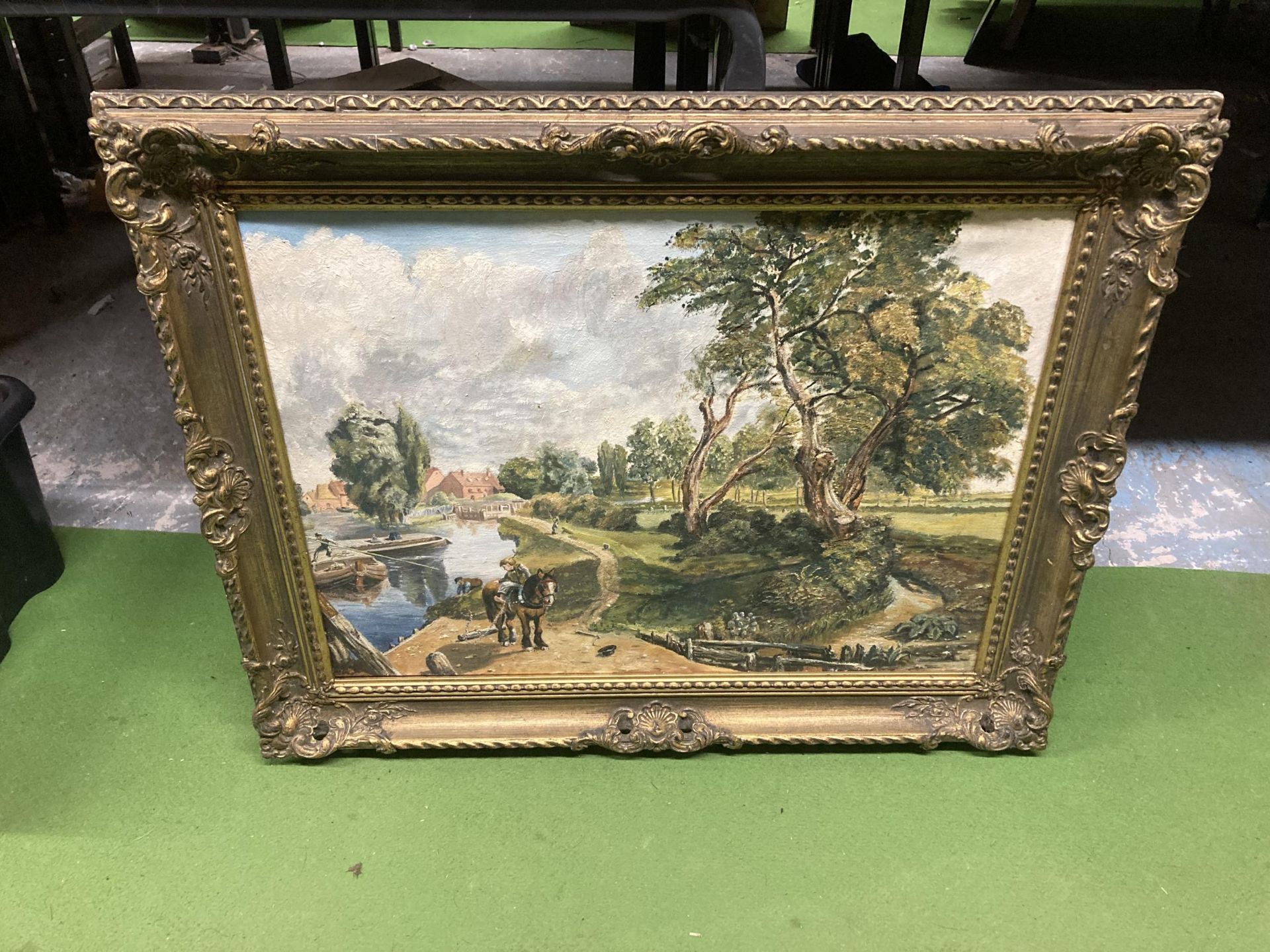 AN ORNATE GILT FRAMED OIL PAINTING OF A RIVERSIDE SCENE WITH SHIRE HORSE