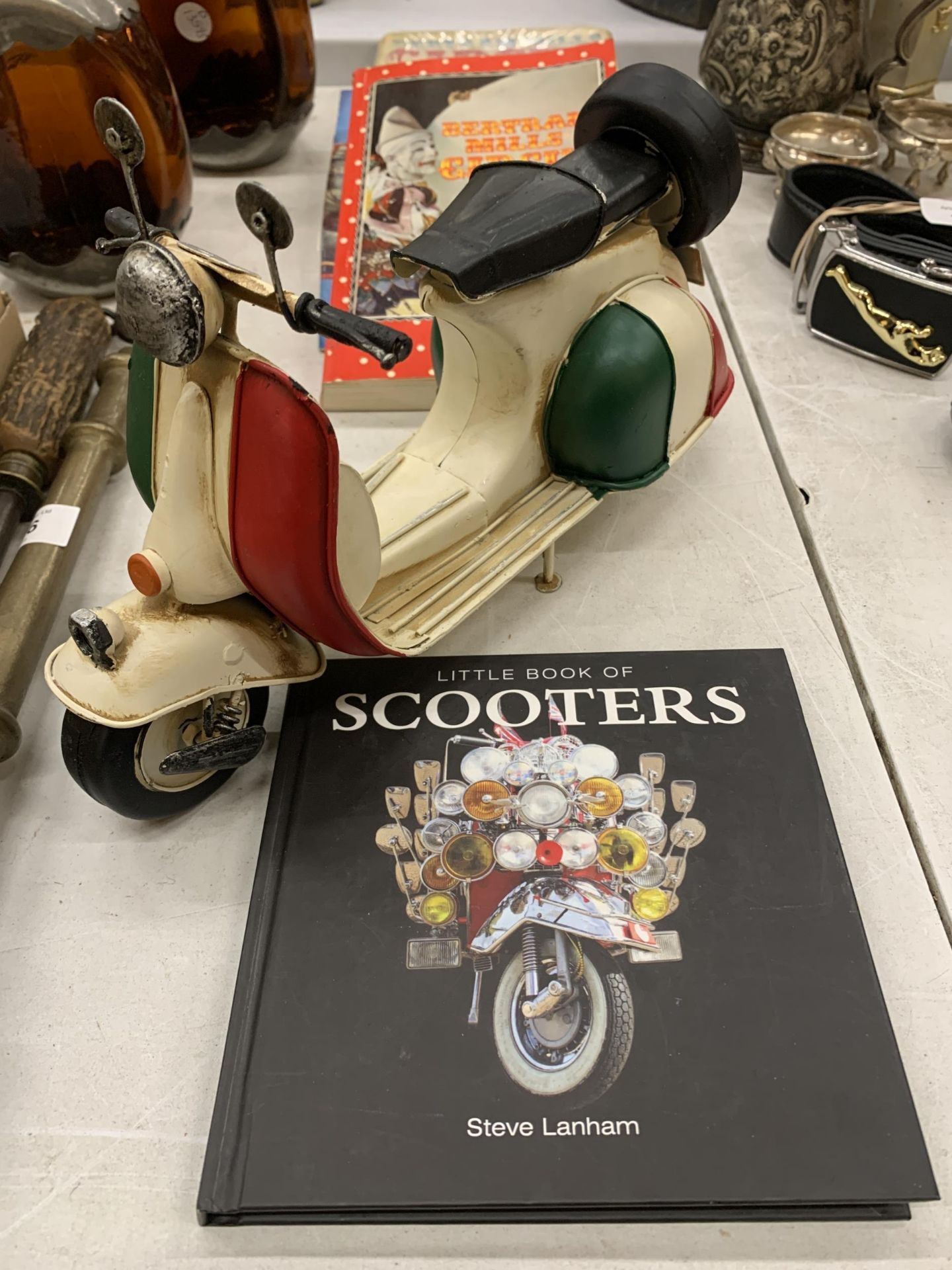 AN ITALIAN TIN PLATE SCOOTER WITH A COLOUR BOOK OF SCOOTERS