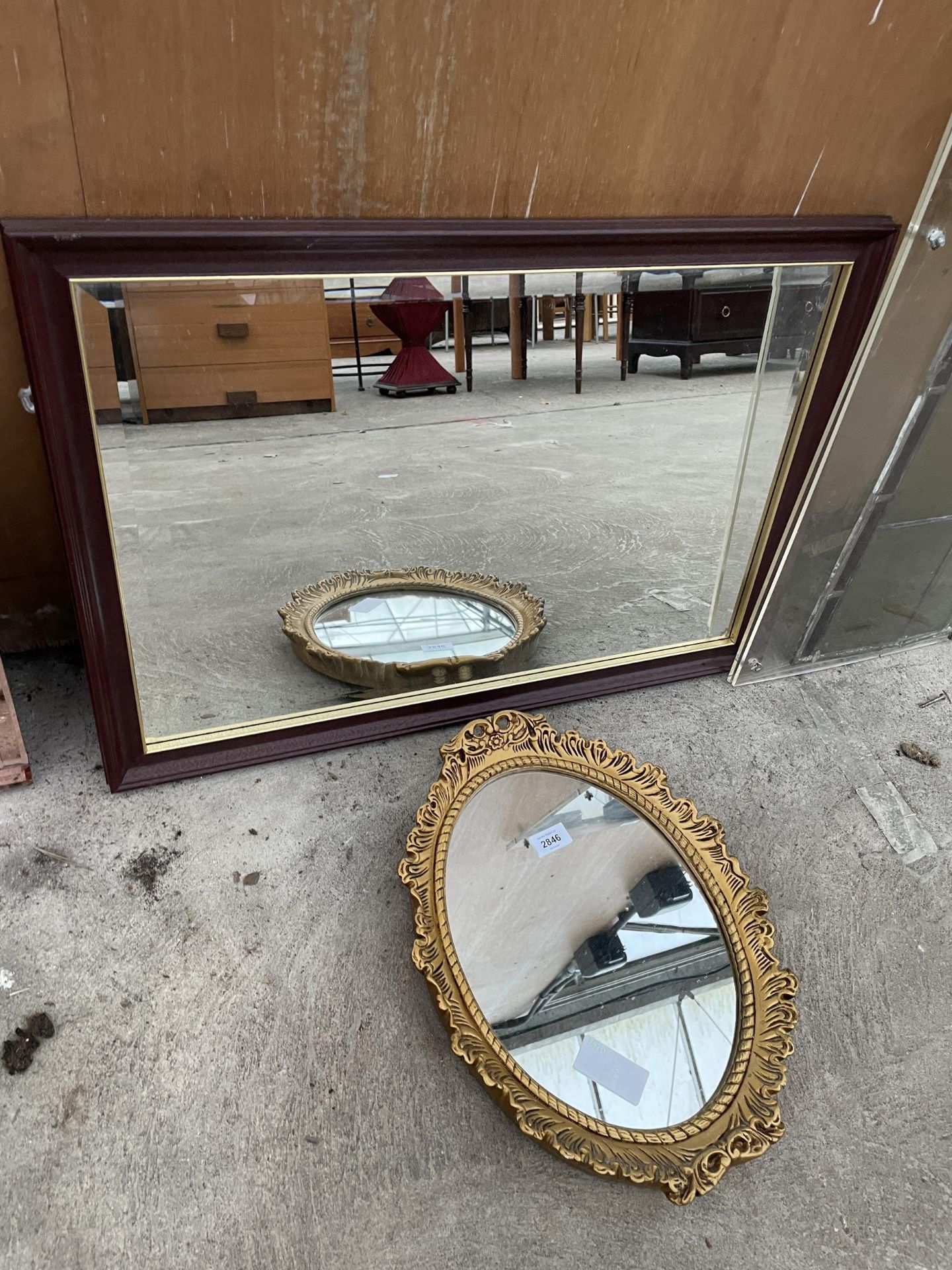 AN OVAL GILT FRAMED WALL MIRROR AND WOODEN FRAMED MIRROR