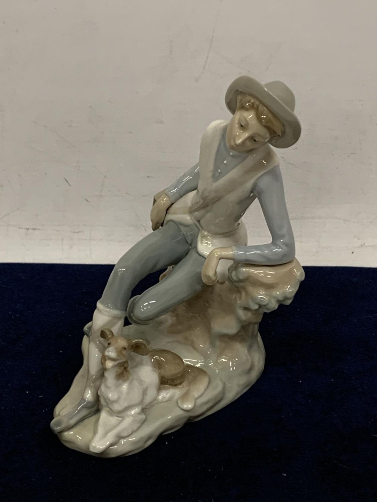 A LLADRO FIGURE OF A BOYS RESTING WITH HIS TERRIER