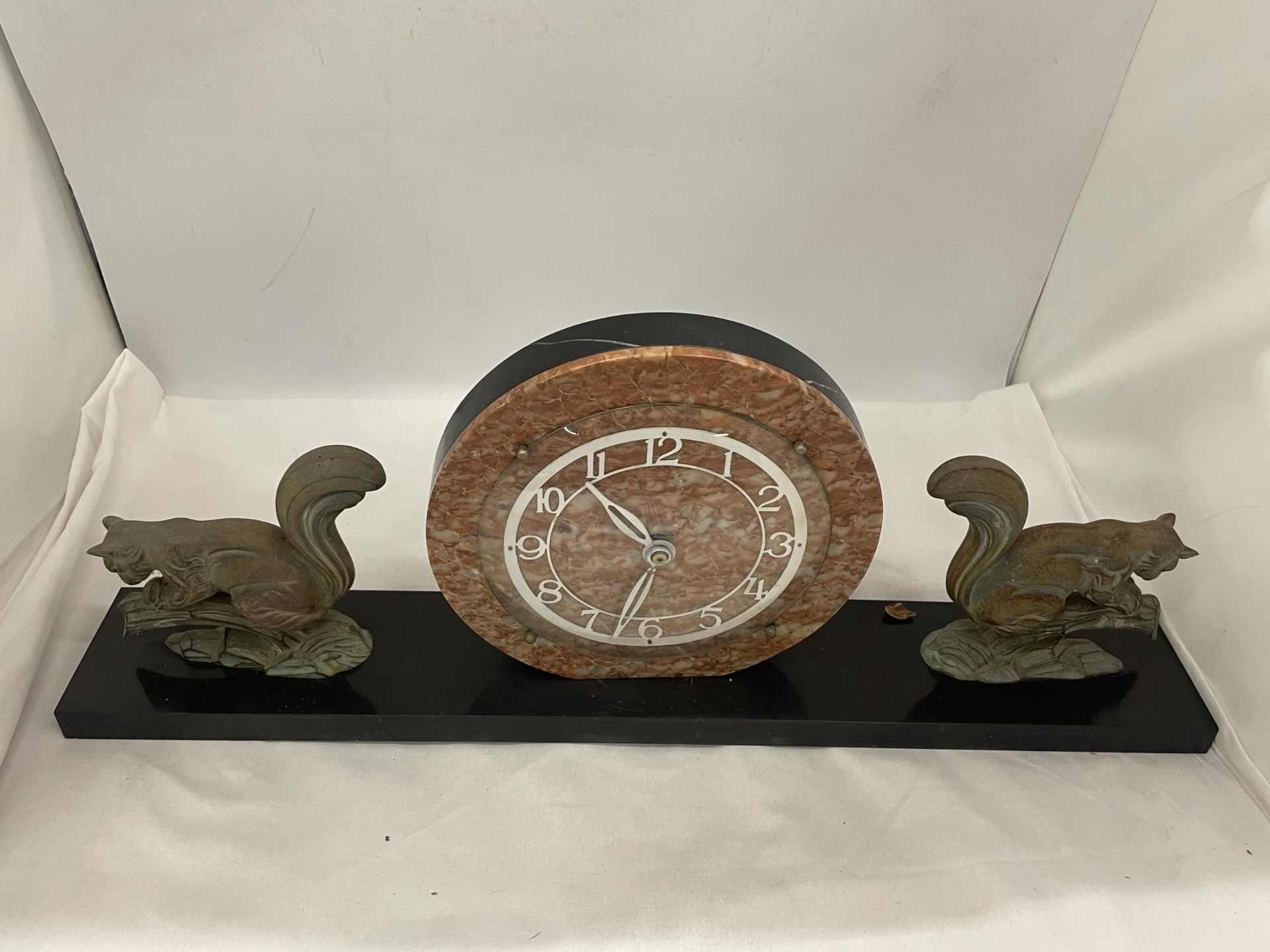 A CONTINENTAL ART DECO CLOCK ON A PLINTH WITH SQUIRREL GARNITURES 23" WIDE