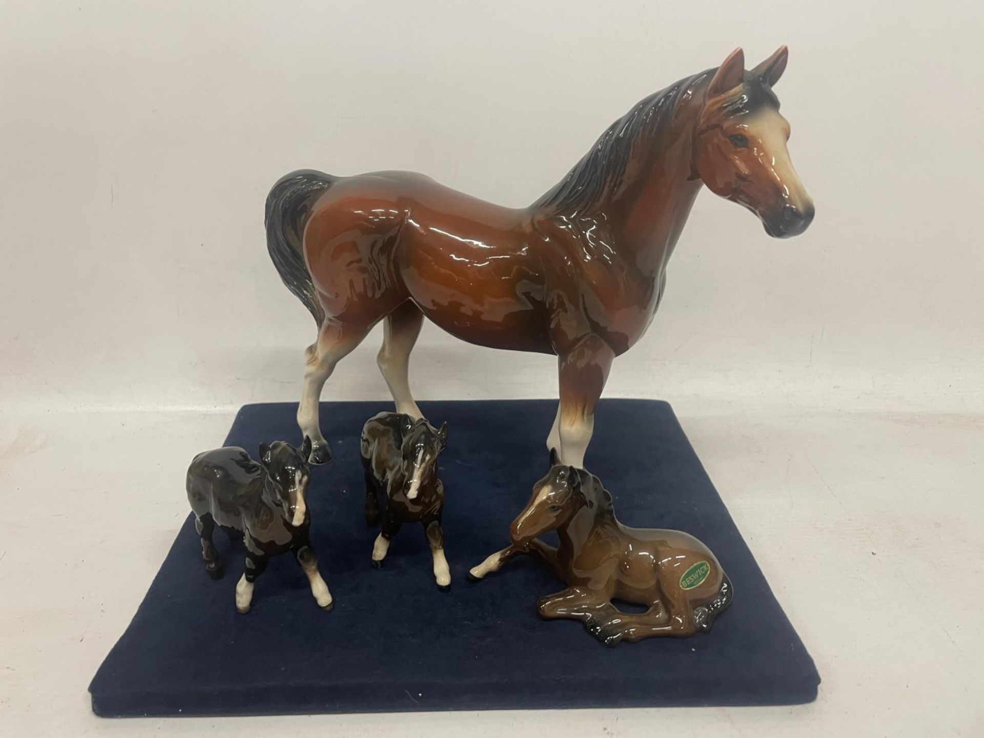 A HORSE (NOT BESWICK) WITH THREE BESWICK FOALS