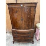 A 19TH CENTURY MAHOGANY AND CROSSBANDED BOWFRONTED PRESS STYLE CUPBOARD WITH THREE GRADUATED DRAWERS