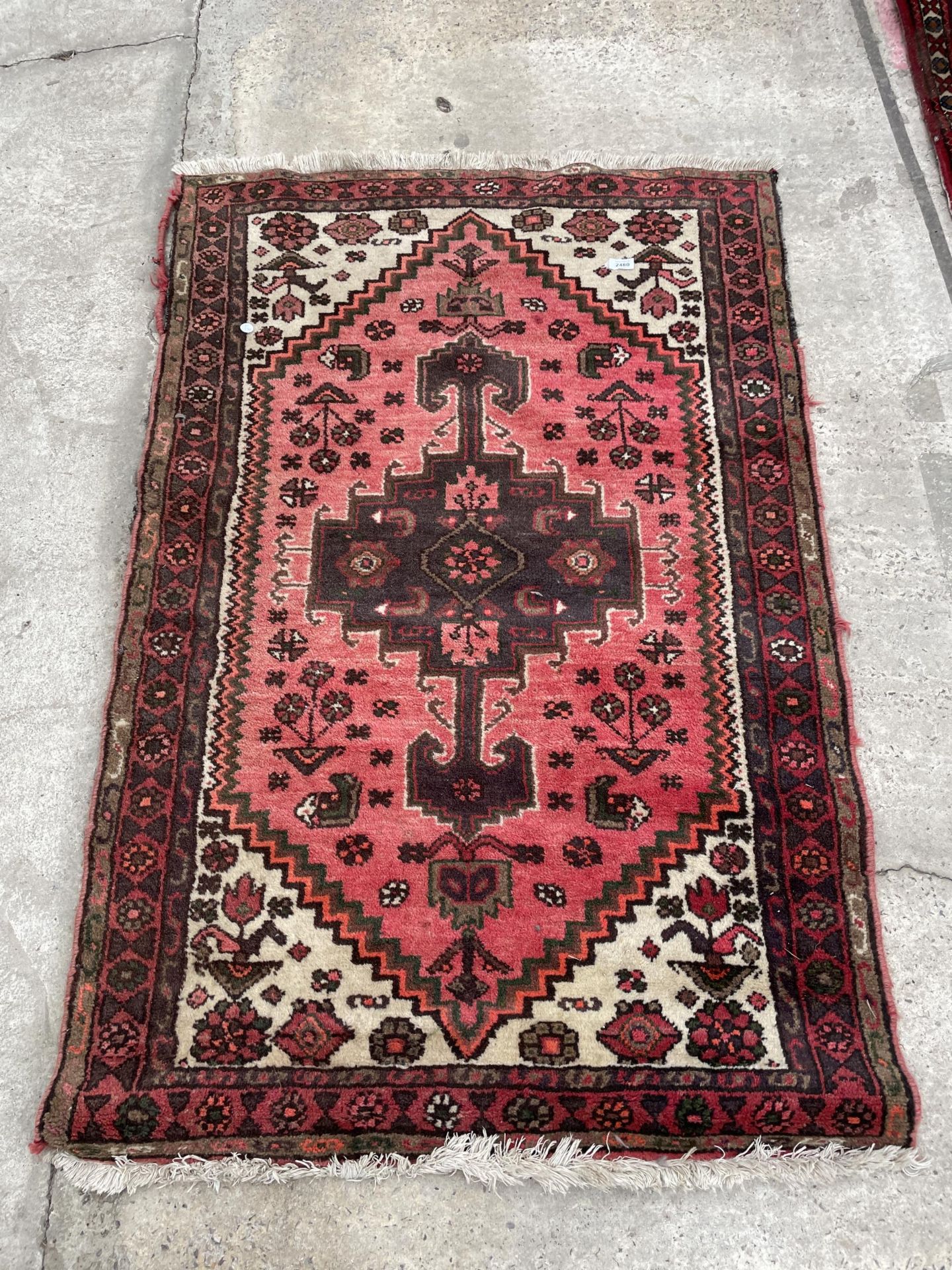 A SMALL RED PATTERENED RUG