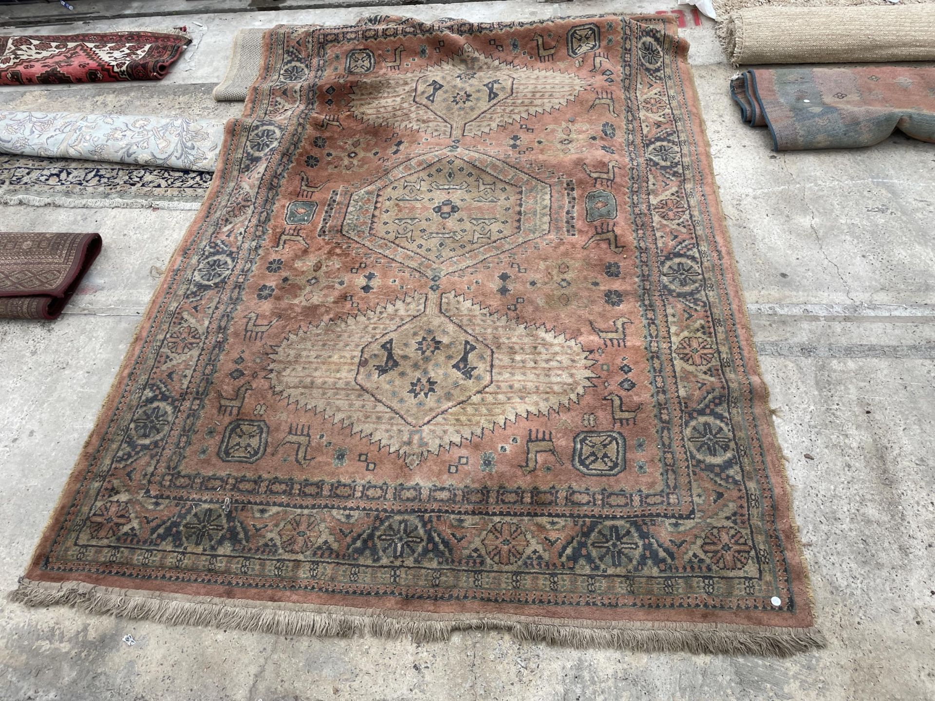 AN ORANGE PATTERNED FRINGED RUG