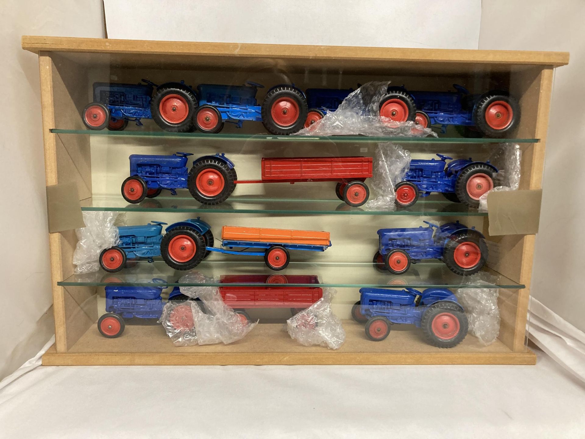 A QUANTITY OF CRENSENT TOYS IN A CABINET TO INCLUDE TEN FORD & SON DEXSTAR AND THREE TRAILERS