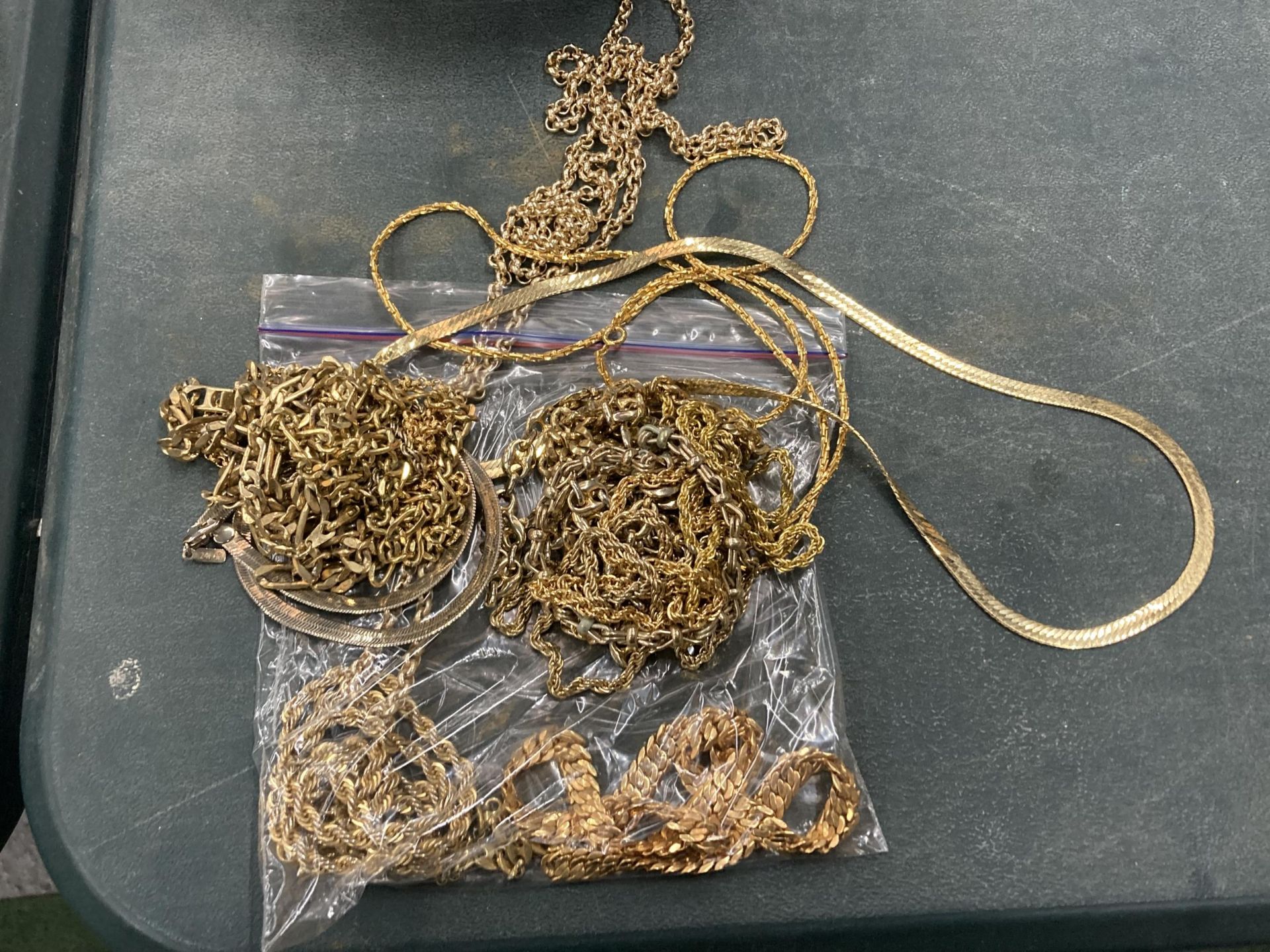A BAG OF YELLOW METAL COSTUME JEWELLERY CHAINS ETC