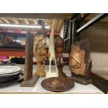A WOODEN CARVED PLAQUE OF A FISHERMAN ON A STAND, WOODEN LOTUS LAMP, A LARGE HORN BIRD, AN