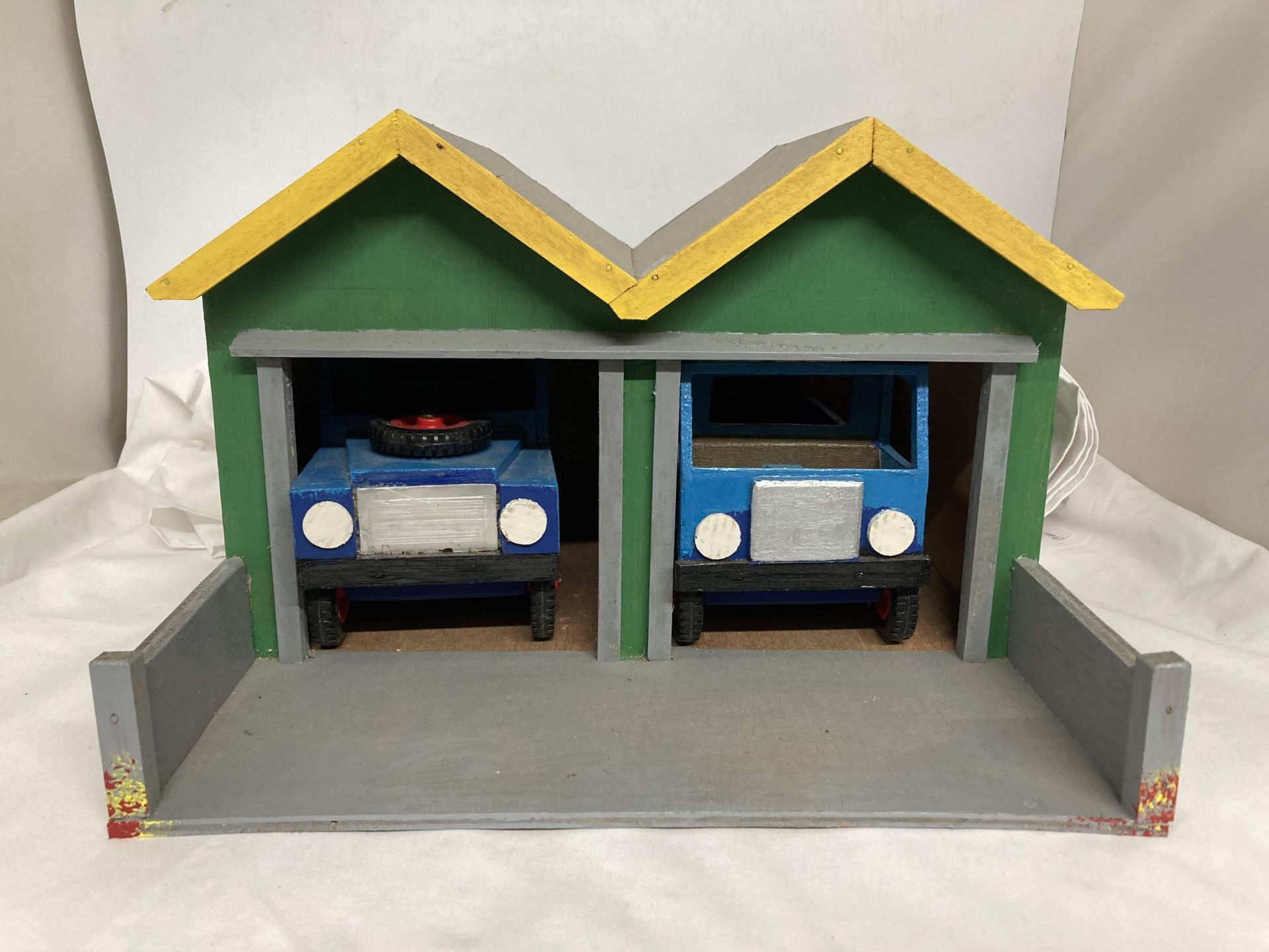 A WOODEN GARAGE HOUSING A WOODEN LANDROVER AND A WOODEN LORRY