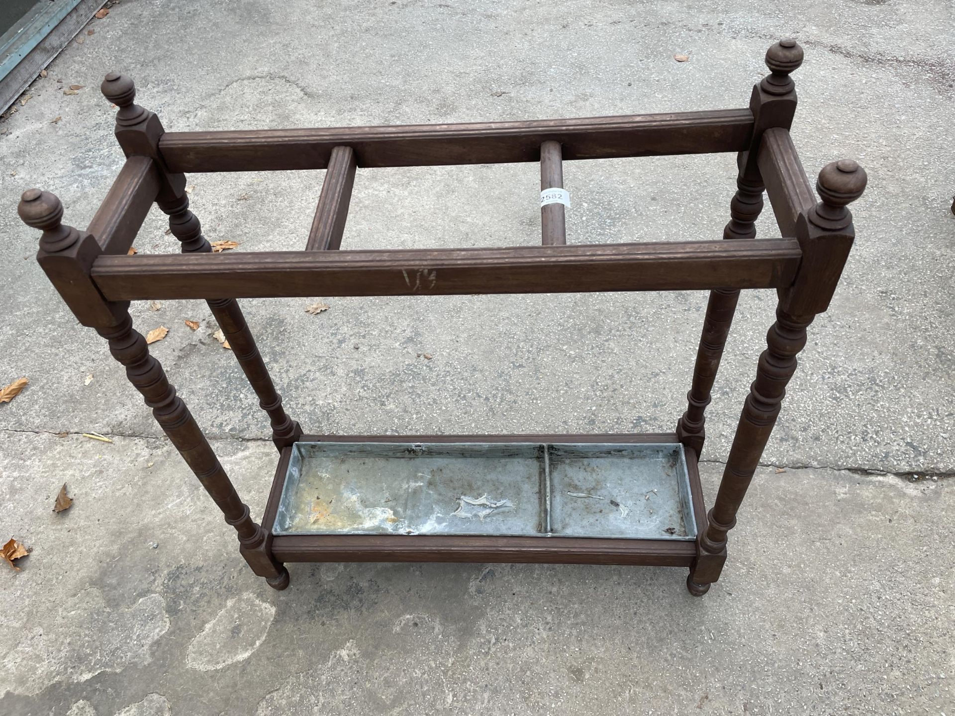 AN EARLY 20TH CENTURY OAK THREE DIVISION STICK STAND ON TURNED LEGS