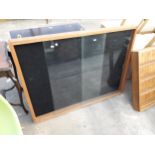 AN OAK FRAMED GLASS FRONTED WALL CABINET