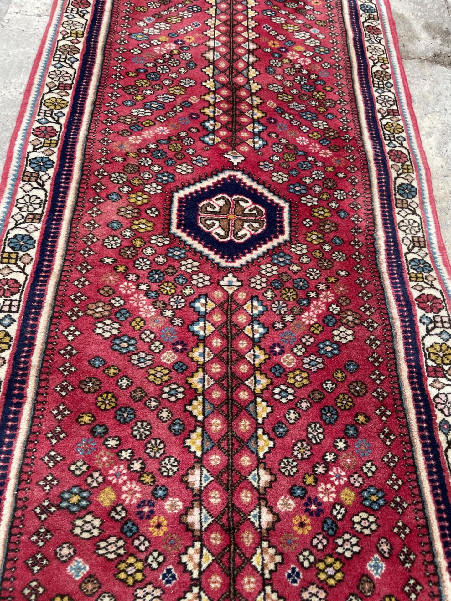 A SMALL RED PATTERNED FRINGED RUG - Bild 2 aus 3
