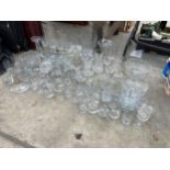 A LARGE ASSORTMENT OF GLASS WARE TO INCLUDE BOWLS, VASES AND DRINKING GLASSES ETC