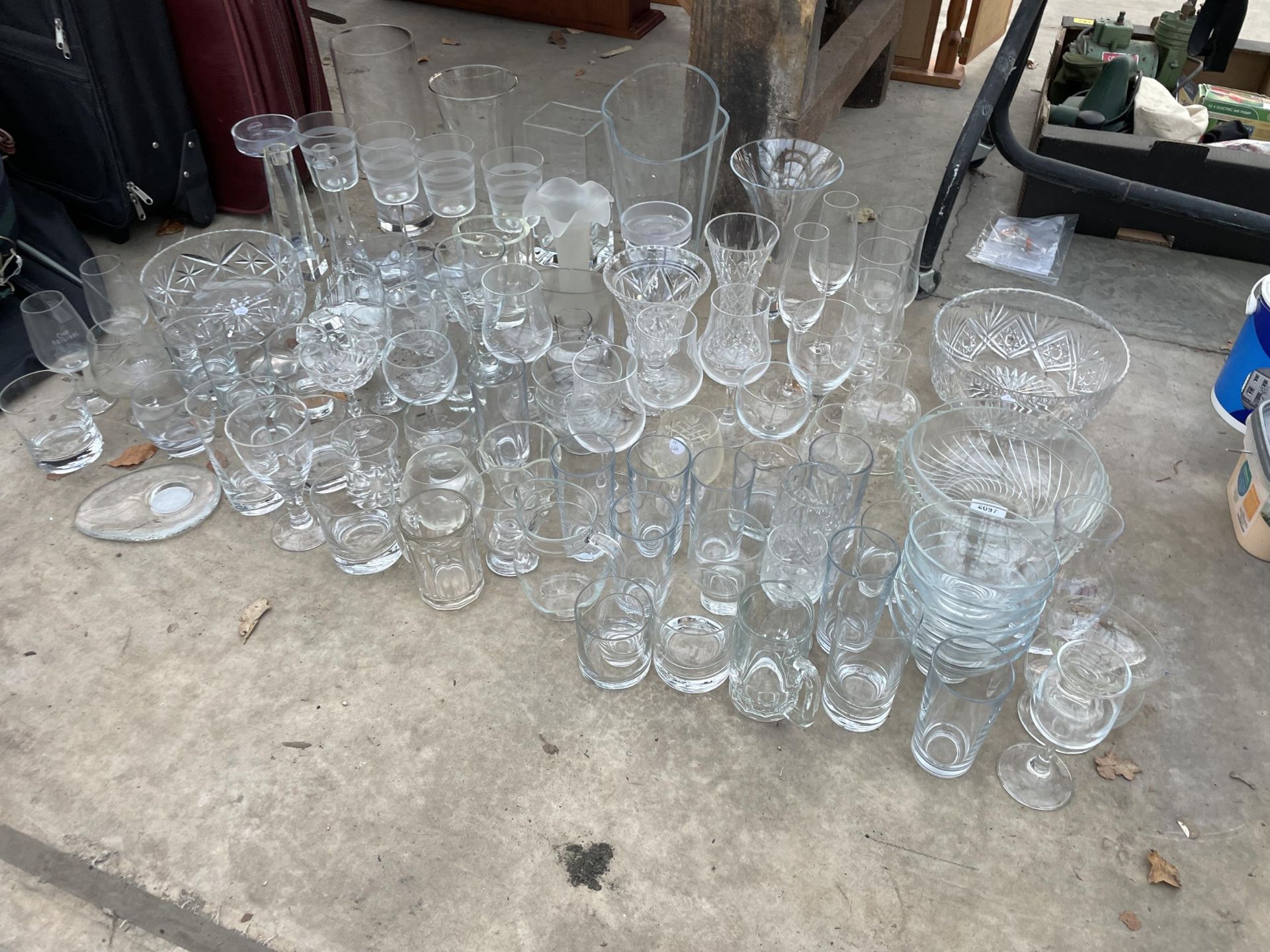 A LARGE ASSORTMENT OF GLASS WARE TO INCLUDE BOWLS, VASES AND DRINKING GLASSES ETC