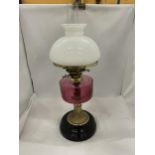 A VINTAGE OIL LAMP WITH WHITE GLASS SHADE, GLASS FUNNEL, CRANBERRY COLOURED GLASS OIL RESERVOIR