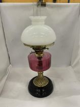 A VINTAGE OIL LAMP WITH WHITE GLASS SHADE, GLASS FUNNEL, CRANBERRY COLOURED GLASS OIL RESERVOIR