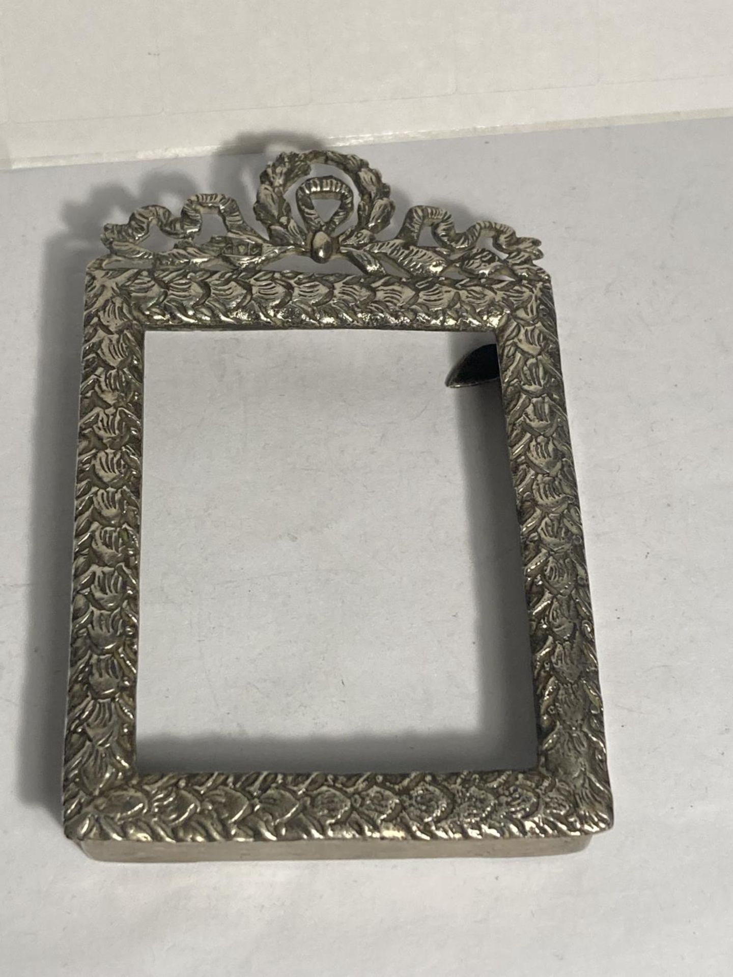 A DECORATIVE SILVER SMALL PHOTOGRAPH FRAME NO GLASS