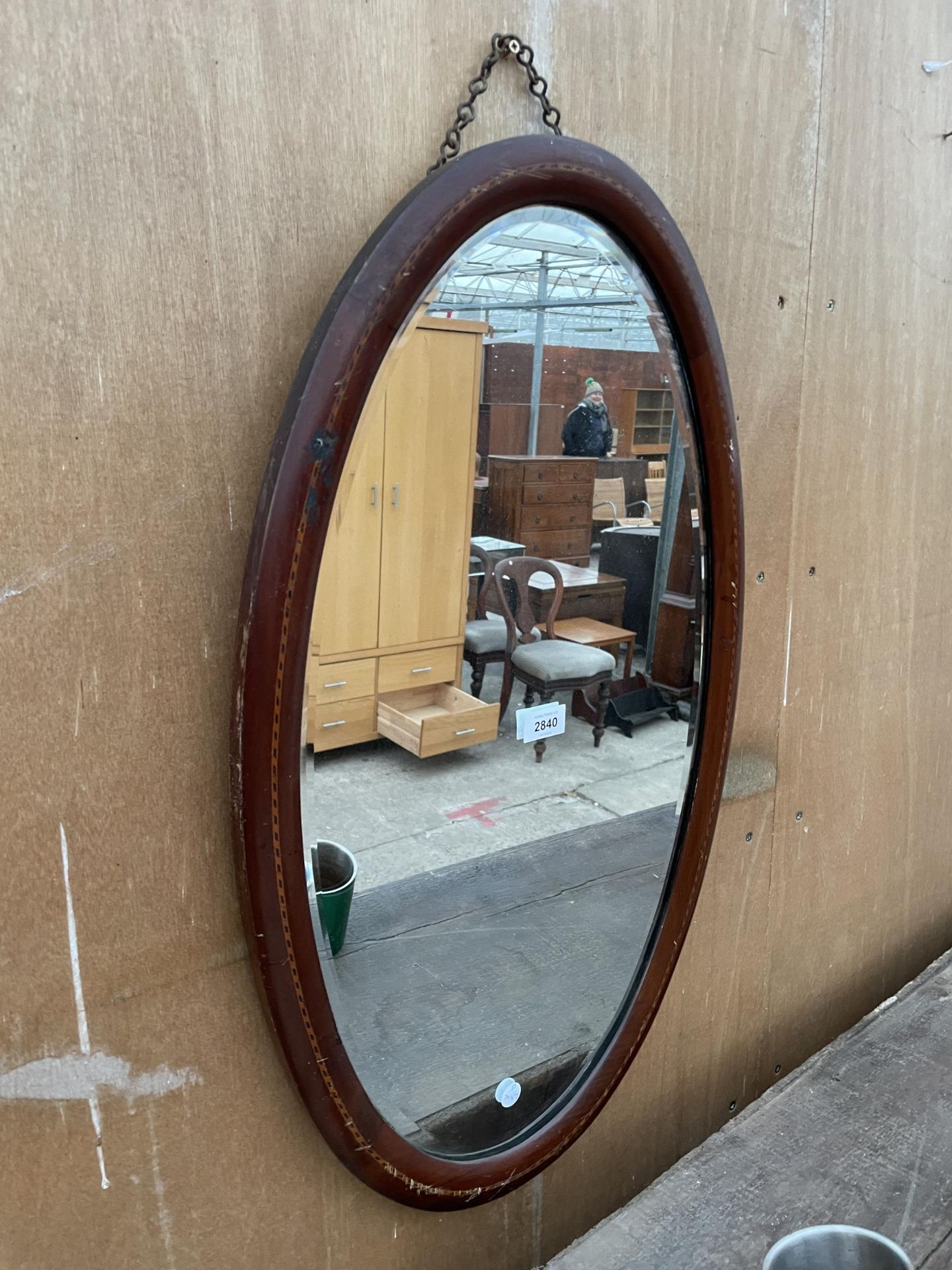 AN OVAL MAHOGANY AND INLAID EDWARDIAN MIRROR