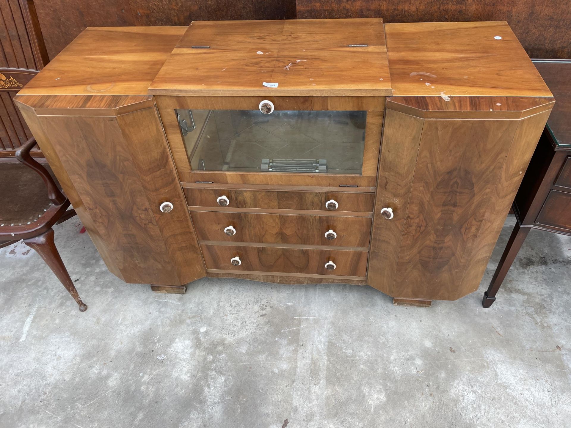 A WALNUT ART DECO COCKTAIL SIDEBOARD WITH MIRRORED DROP-DOWN FRONT, TWO CUPBOARDS AND THREE DRAWERS,