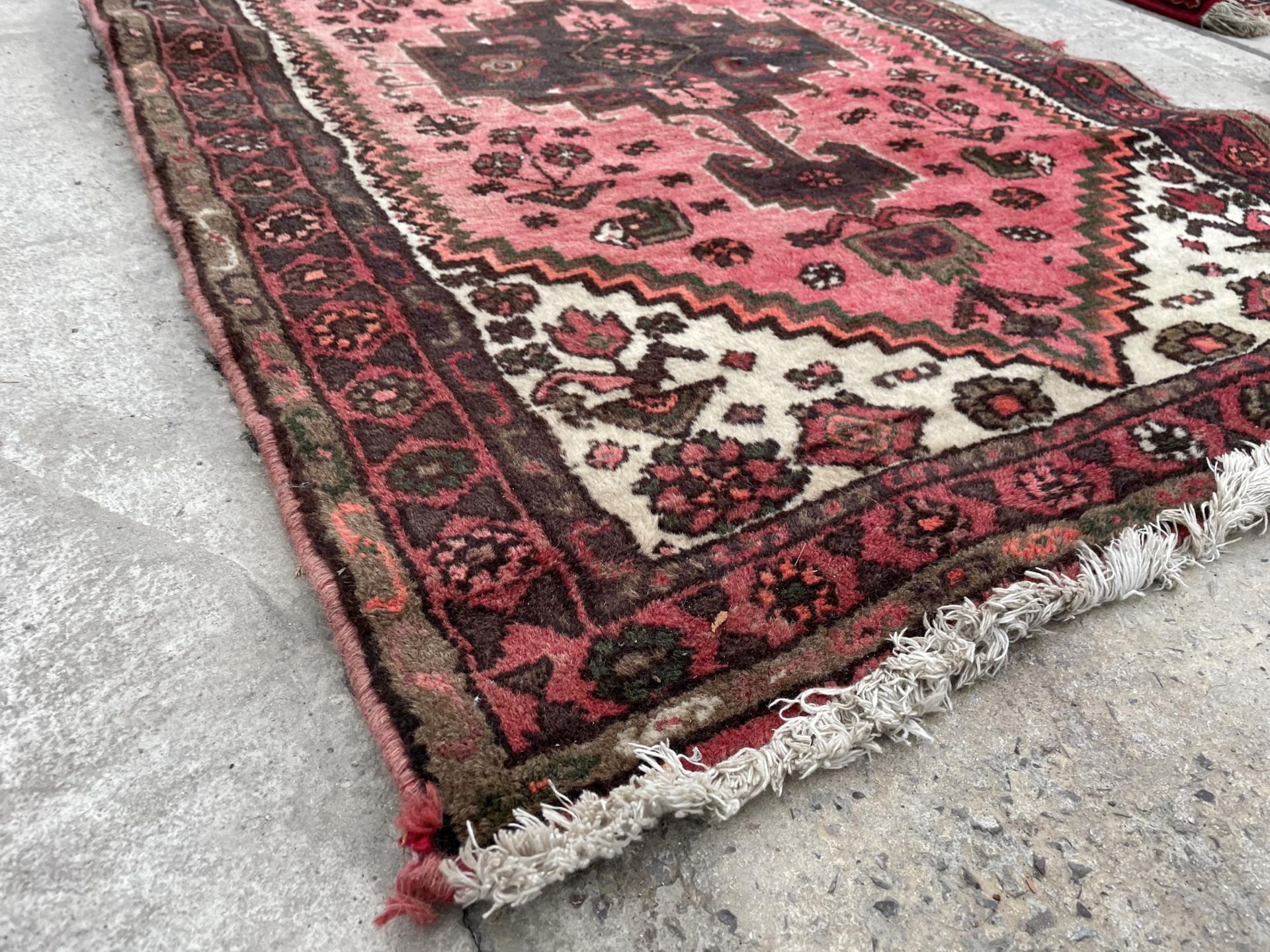 A SMALL RED PATTERENED RUG - Image 2 of 2