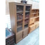A MODERN OAK EFFECT TWO DOOR GLAZED BOOKCASE WITH CUPBOARDS TO THE BASE, 36" WIDE