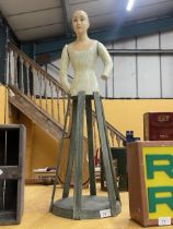 AN UNUSUAL PAINTED WOODEN DOLL ON STAND WITH MOVEABLE ARMS