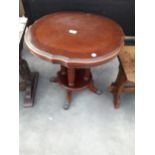 A THESEIRA 23" DIAMETER OCCASIONAL TABLE ON FOUR TURNED AND FLUTED COLUMNS WITH BRASS CLAW FEET