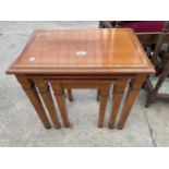 A GRANGE CHERRY WOOD NEST OF THREE TABLES ON TAPERING LEGS, WITH BRASS FEET