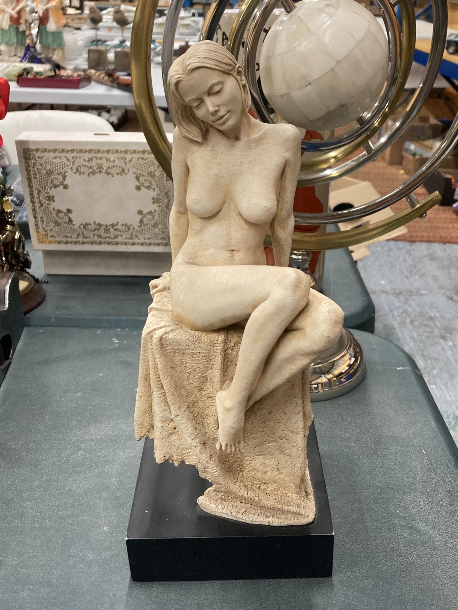 A STATUE OF A NUDE WOMAN ON BLACK BASE