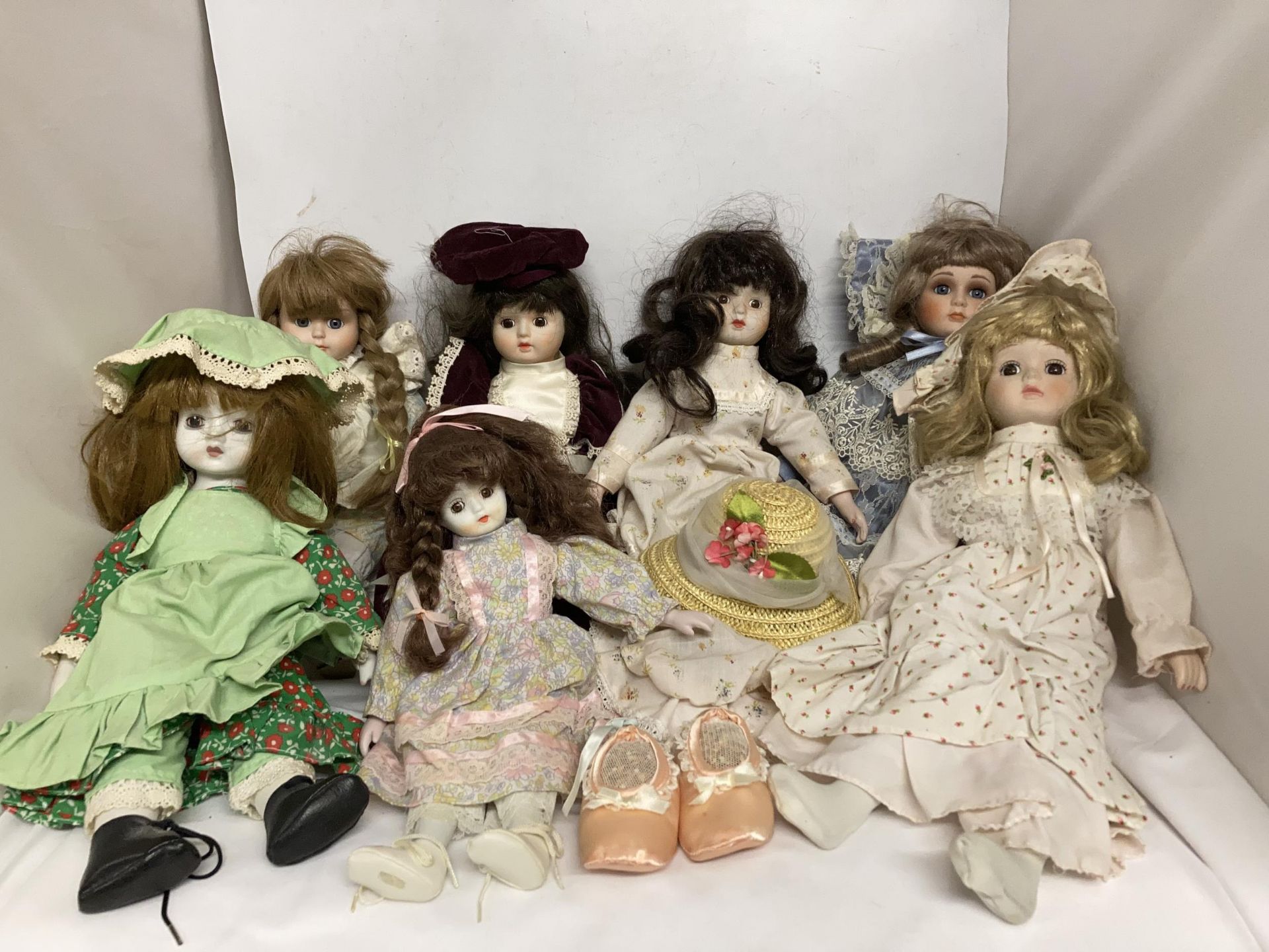 A COLLECTION OF PORCELAIN HEADED DOLLS IN COSTUMES - 7 IN TOTAL