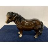 A CERAMIC FIGURE OF A SHETLAND PONY