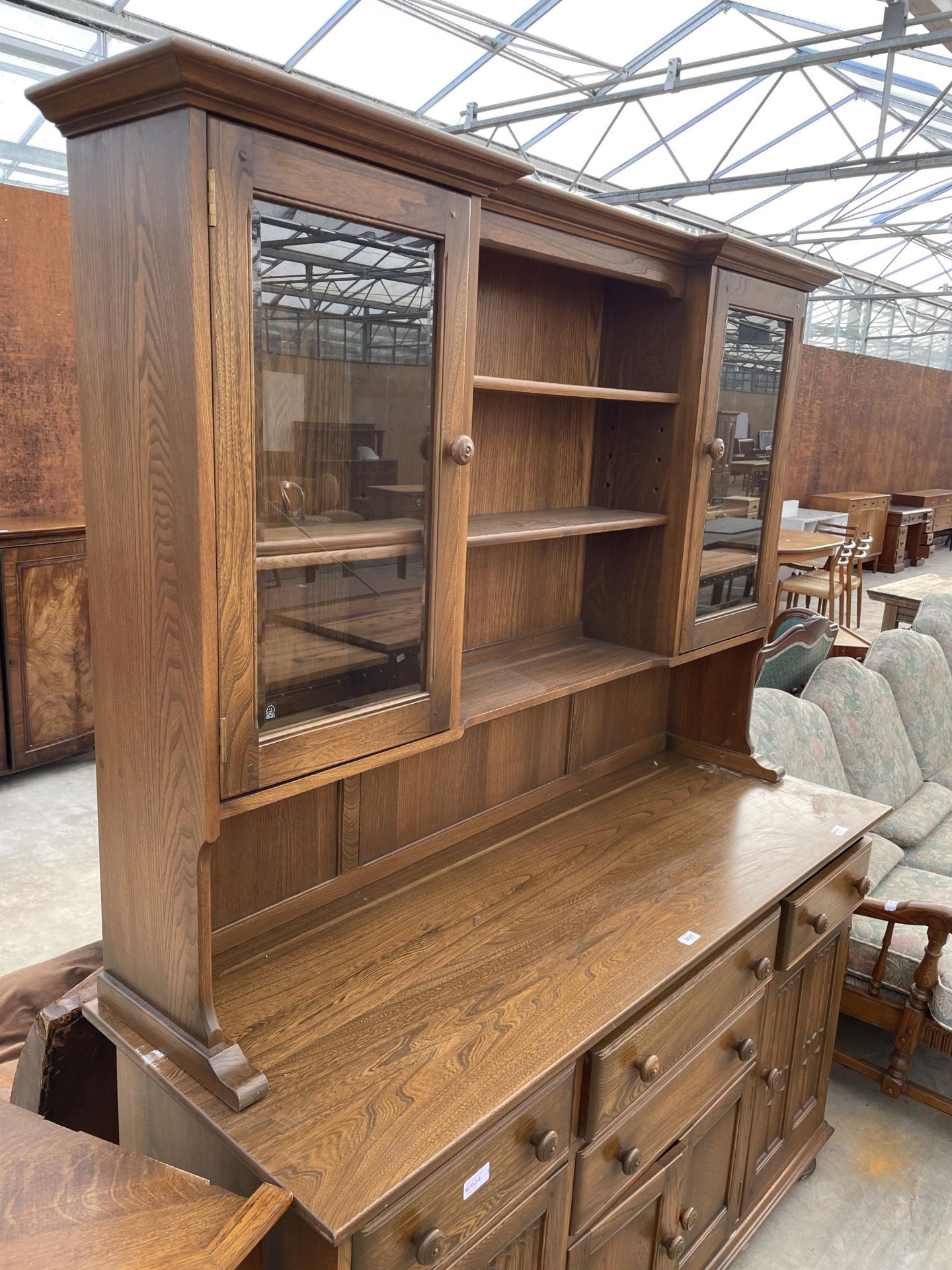 AN ERCOL ELM DRESSER WITH FOUR DRAWERS AND CUPBOARDS TO THE BASE, THE UPPER PORTION HAVING SHELVES - Image 2 of 5