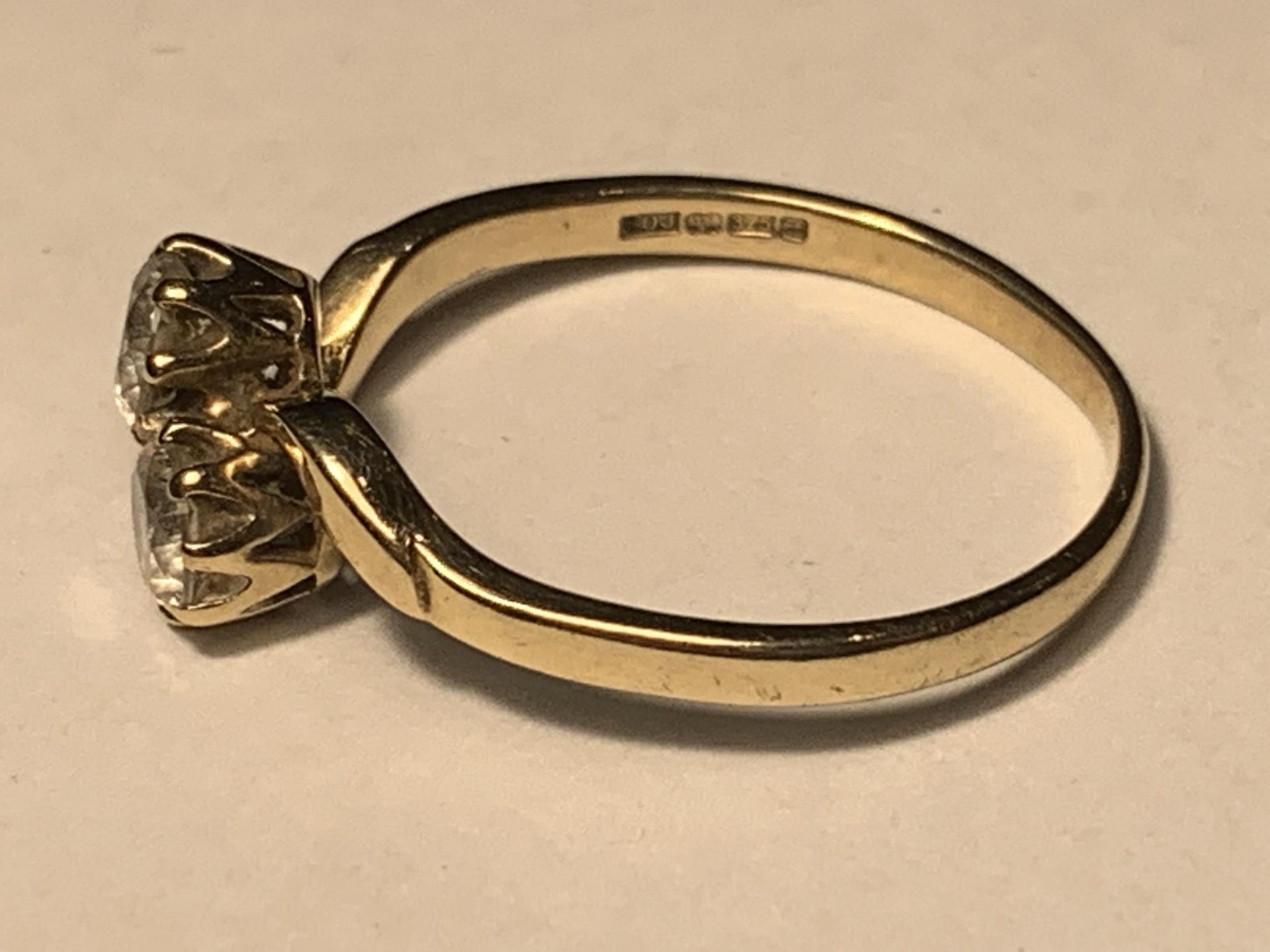 A 9 CARAT GOLD RING WITH TWO CUBIC ZIRCONIAS ON A TWIST DESIGN SIZE J - Image 2 of 3