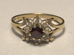 A 9 CARAT GOLD RING WITH CENTRE GARNET SURROUNDED BY CUBIC ZIRCONIAS SIZE L