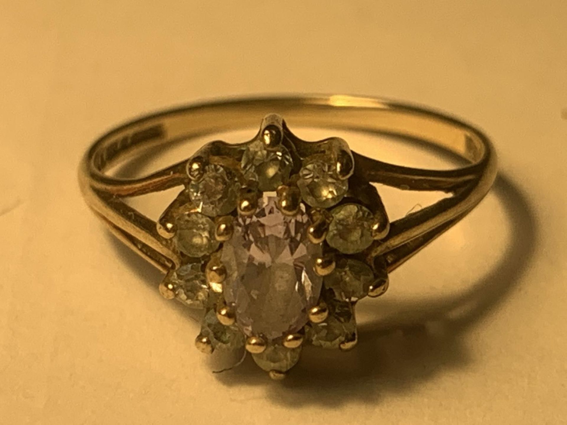 A 9 CARAT GOLD RING WITH CUBIC ZIRCONIAS IN A FLOWER DESIGN SIZE M GROSS WEIGHT 1.7 GRAMS