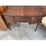 AN EDWARDIAN MAHOGANY AND INLAID KNEEHOLE DESK ENCLOSING FIVE DRAWERS AND TAPERING LEGS WITH SPADE