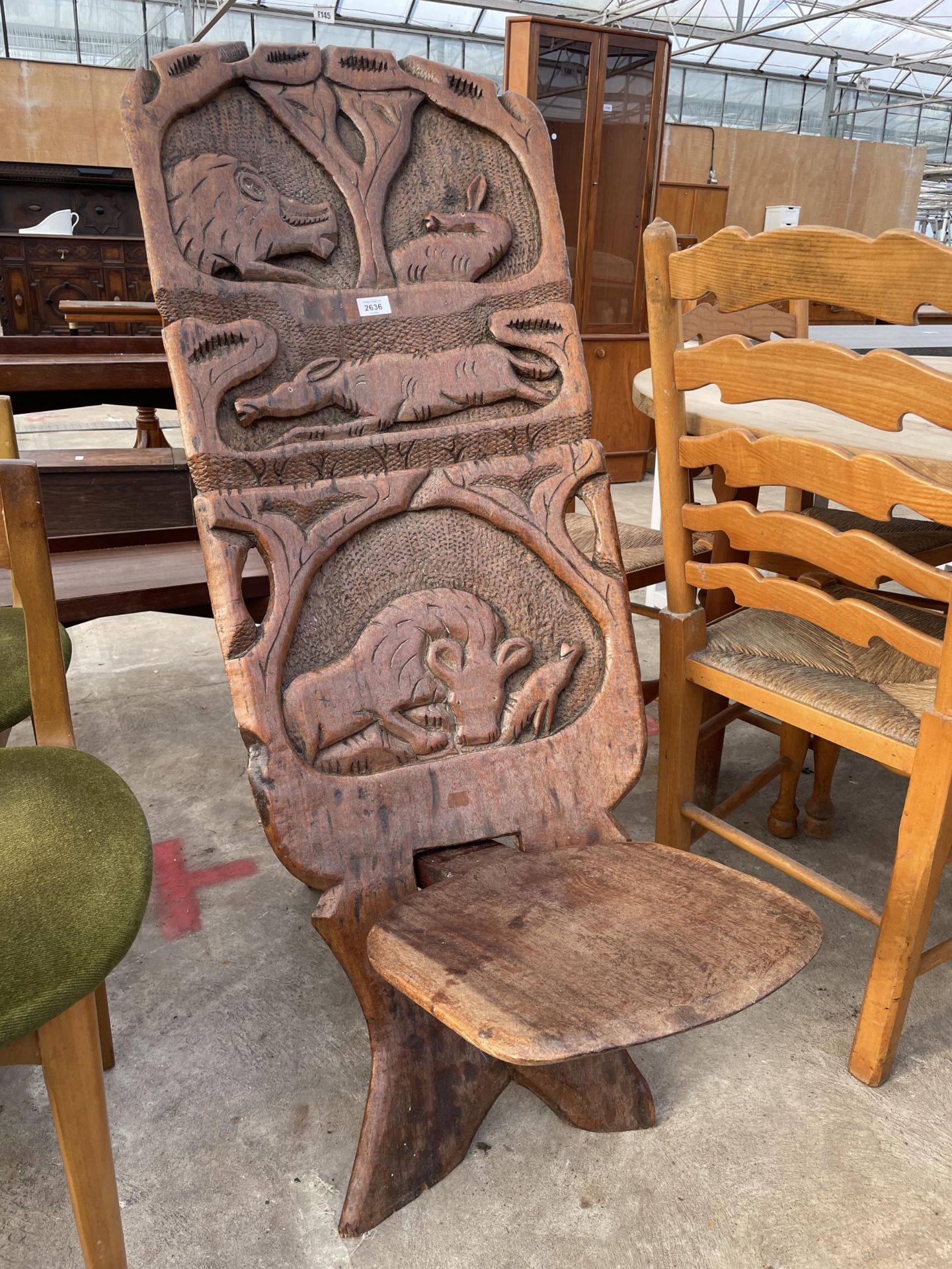 AN AFRICAN FOLDING TRIBAL CHAIR WITH WILD ANIMAL CARVINGS TO BACK