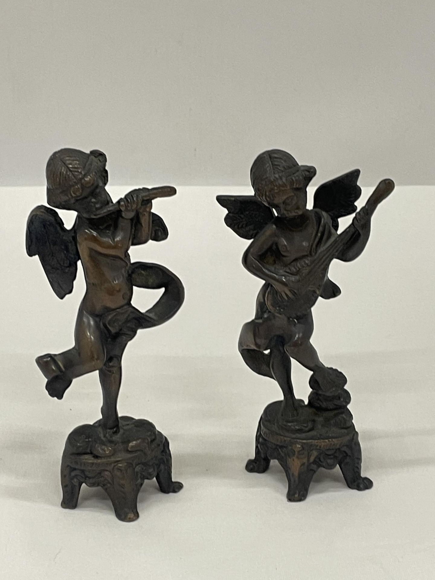 A PAIR OF BRONZE CHERUBS ONE PLAYING A LUTE AND ONE A FLUTE APPROXIMATELY 6 INCHES TALL