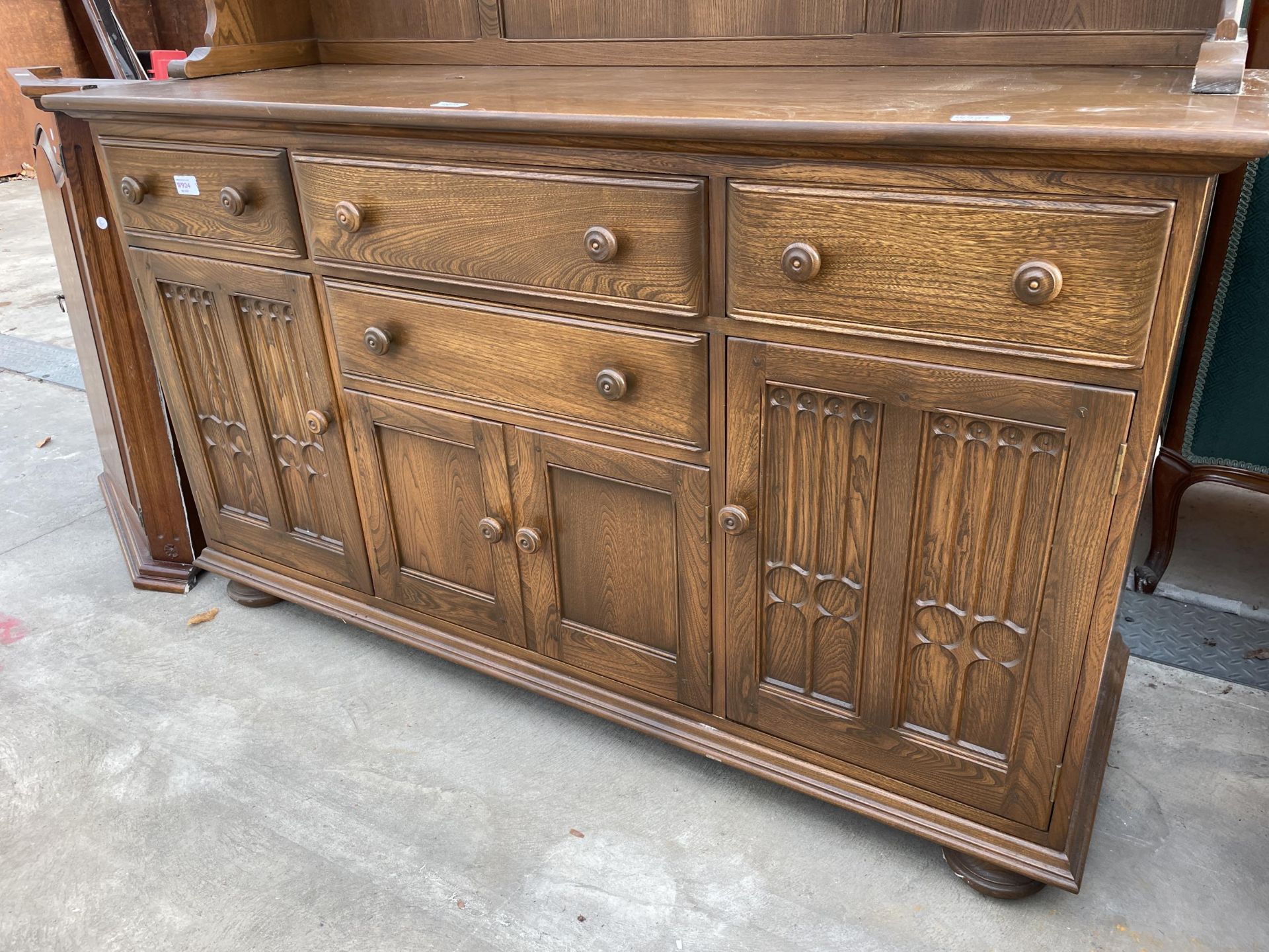 AN ERCOL ELM DRESSER WITH FOUR DRAWERS AND CUPBOARDS TO THE BASE, THE UPPER PORTION HAVING SHELVES - Image 3 of 5