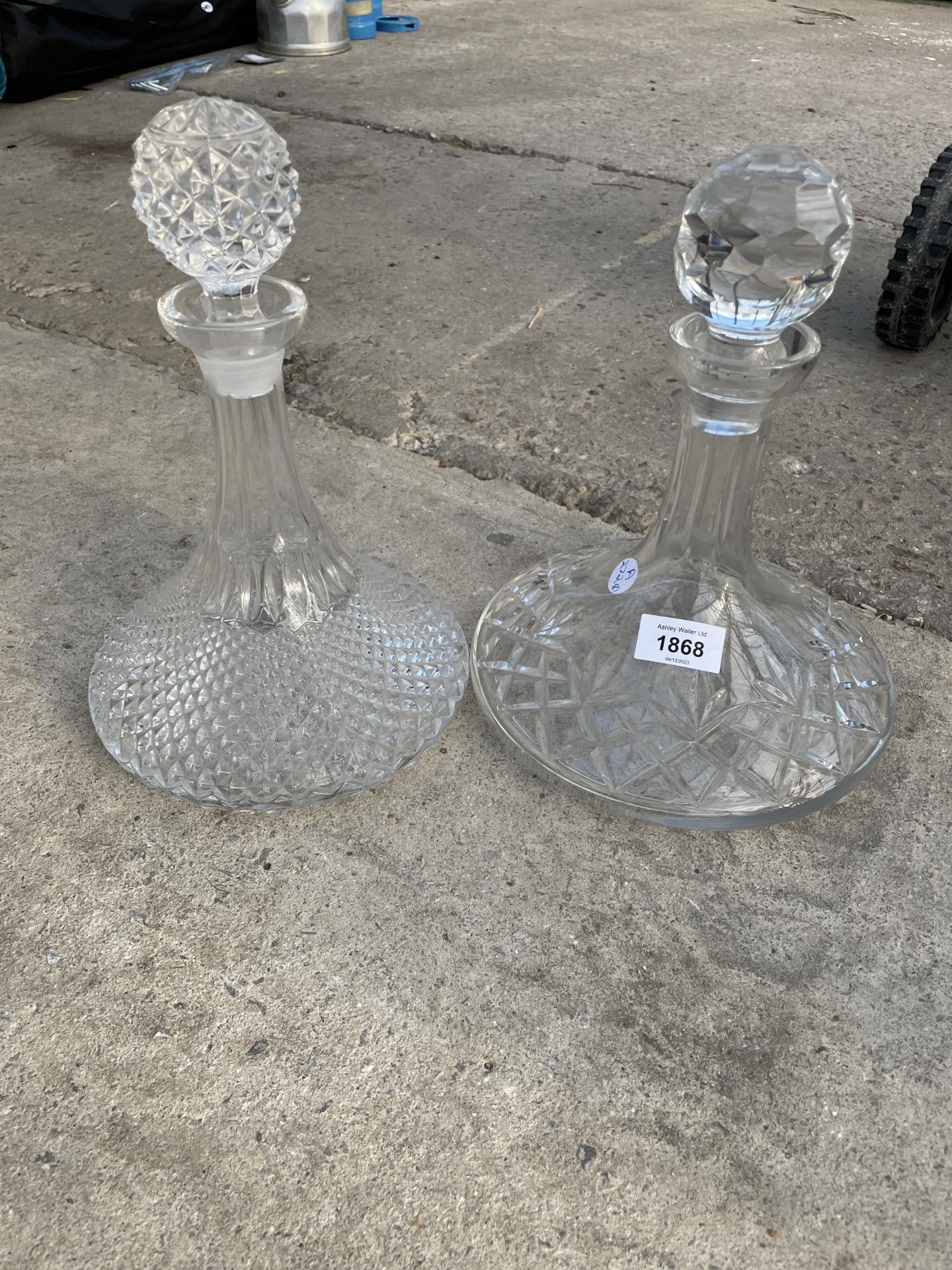 TWO HEAVY CUT GLASS DECANTORS WITH STOPPERS