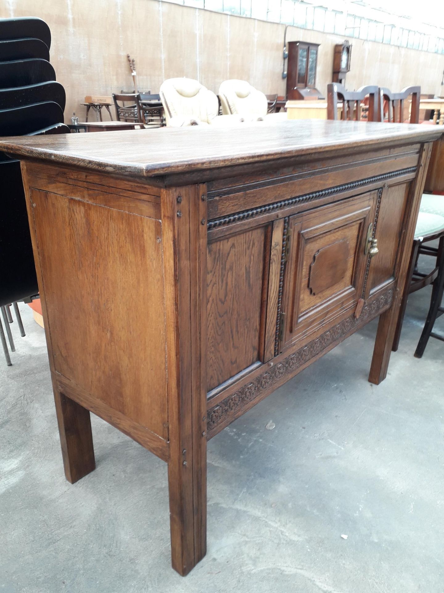 AN EARLY 20TH CENTURY OAK SIDE-CABINET WITH SINGLE DRAWER AND CARVED PANELS, 44" WIDE - Image 2 of 3