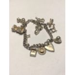 A SILVER CHARM BRACELET WITH ELEVEN CHARMS AND A HALLMARKED BIRMINGHAM SILVER HEART PADLOCK